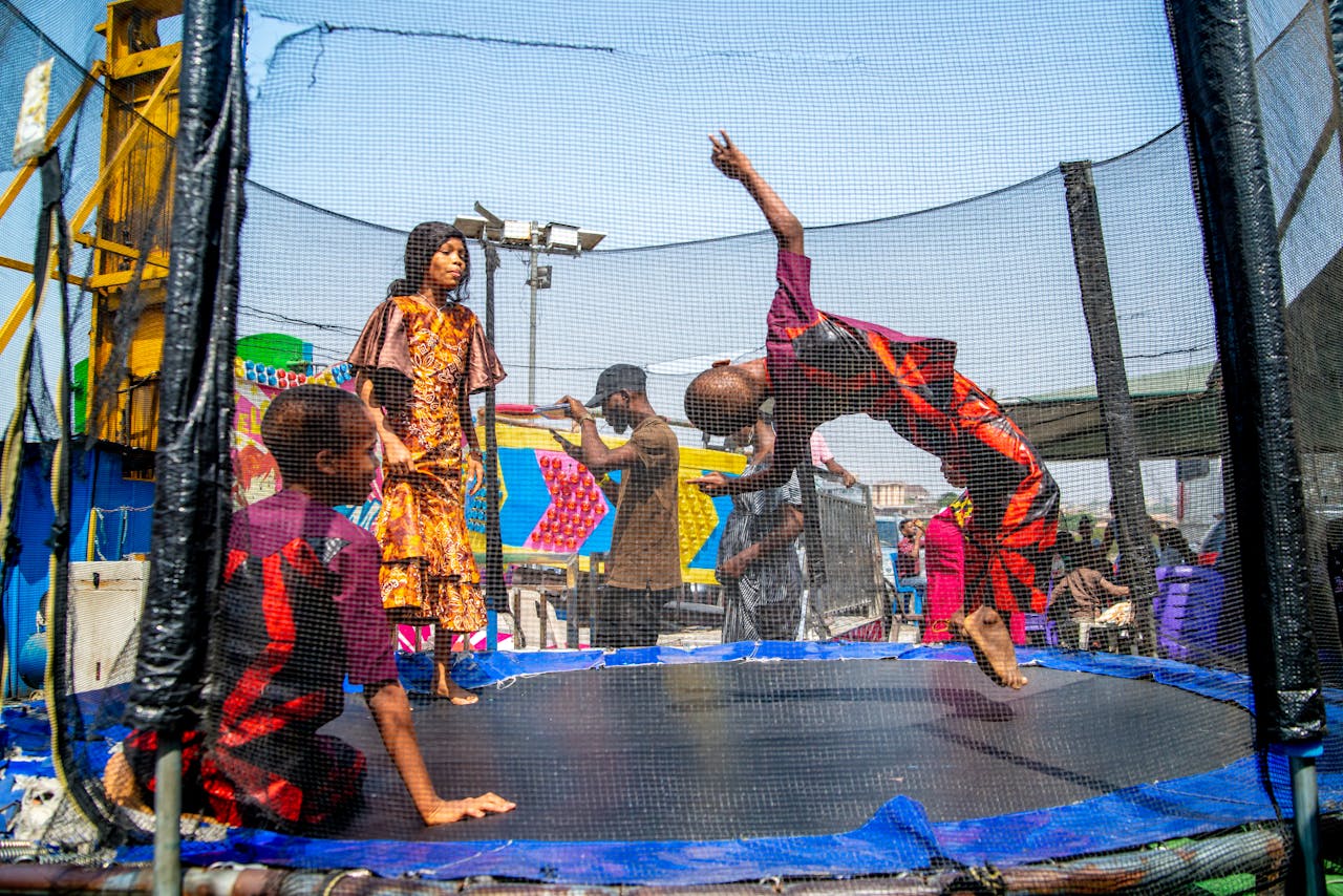 hero-img-01 Joyful scene of children playing energetically on a trampoline in Ibadan, Nigeria.